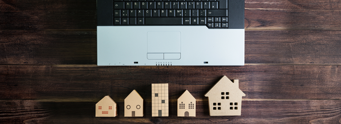Des modèles de maisons en bois et un ordinateur portable